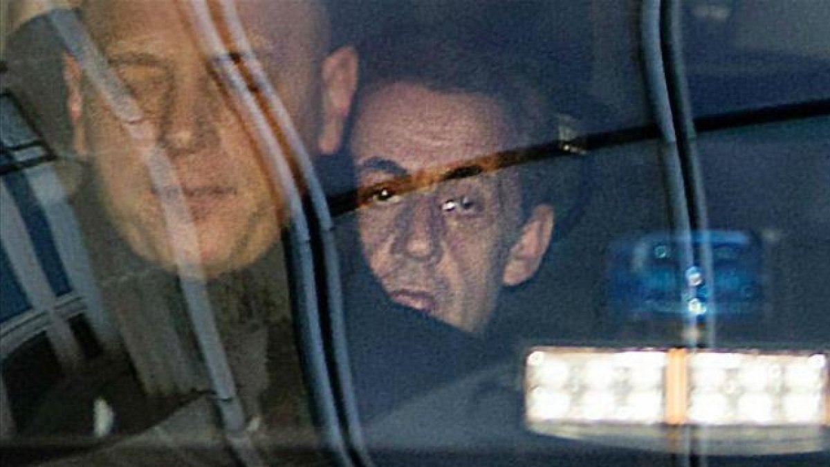 Sarkozy (detrás), a su llegada al tribunal de París para declarar por el 'caso Bygmalion'.-AFP / THOMAS SAMSON