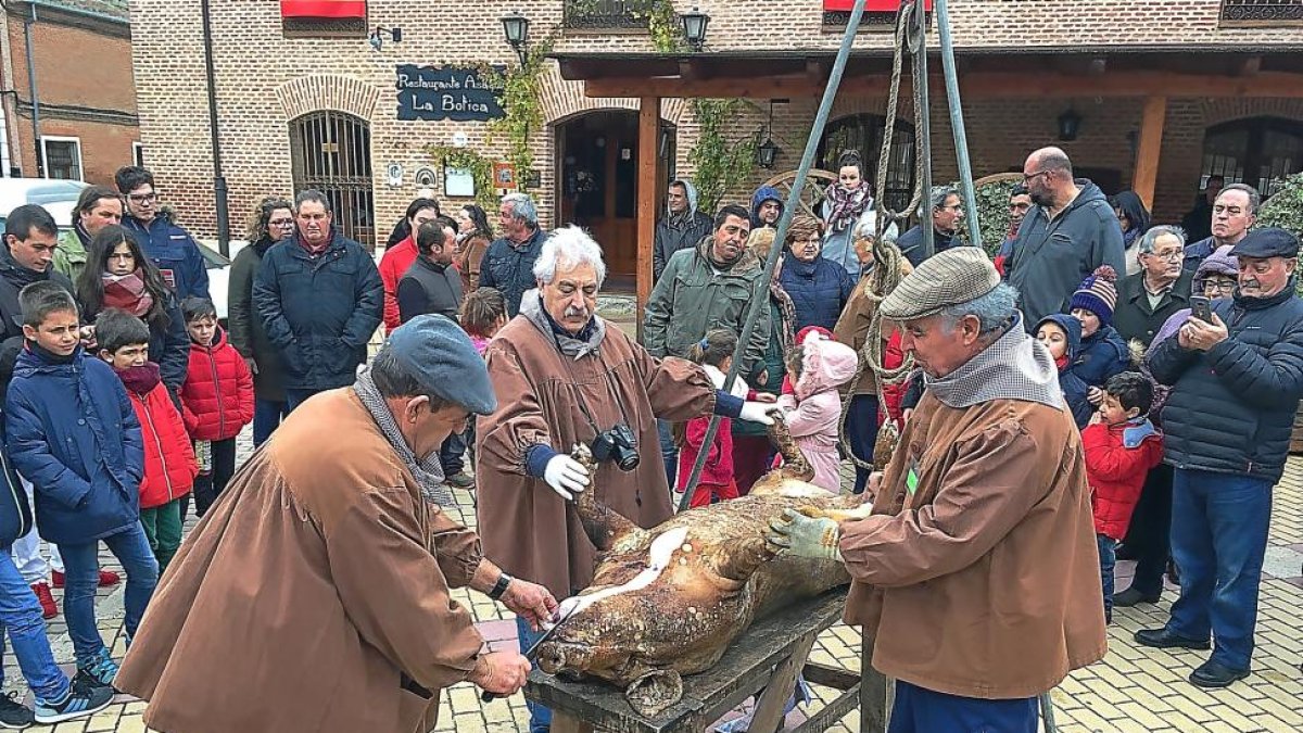 Momento en el que abren al marrano ante la expectación de los vecinos.-M. C.