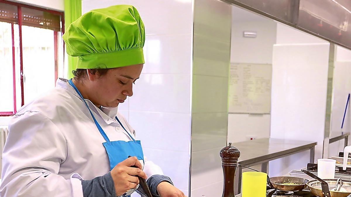Una estudiante de cocina trabaja en la elaboración de un plato en los fogones de una escuela.-ICAL