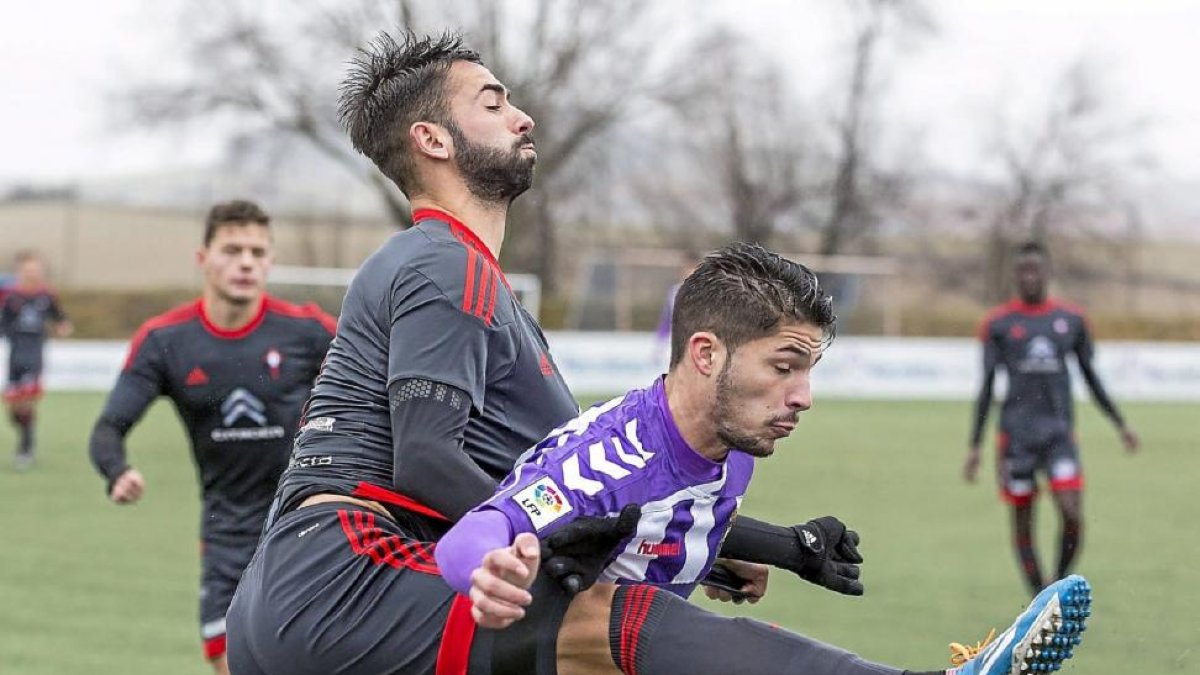 Un jugador del Celta B intenta despejar sin miramientos ante la presencia de Caye Quintana.-Miguel Ángel Santos
