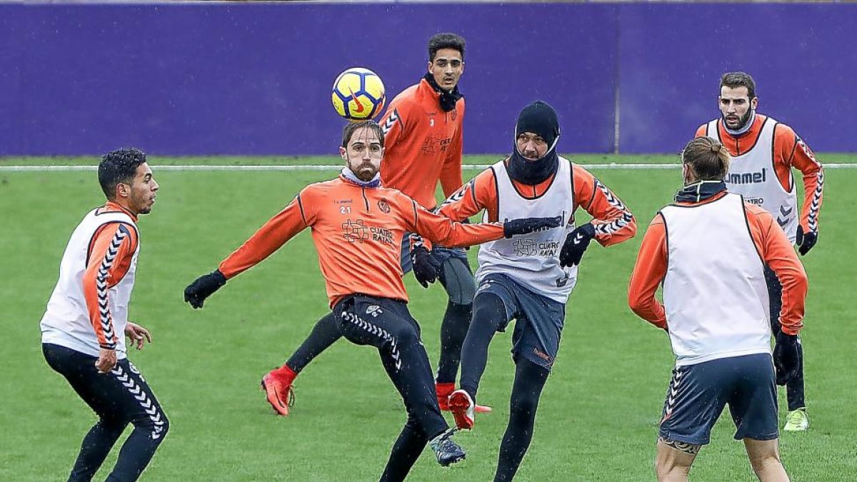 Míchel, en el centro, intenta controlar el balón ante Anuar, Deivid y Ramos.-J.M. LOSTAU