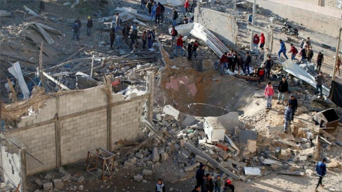 Varios palestinos observan los destrozos del bombardeo israelí de este sábado en Gaza.-REUTERS / MOHAMMED SALEM