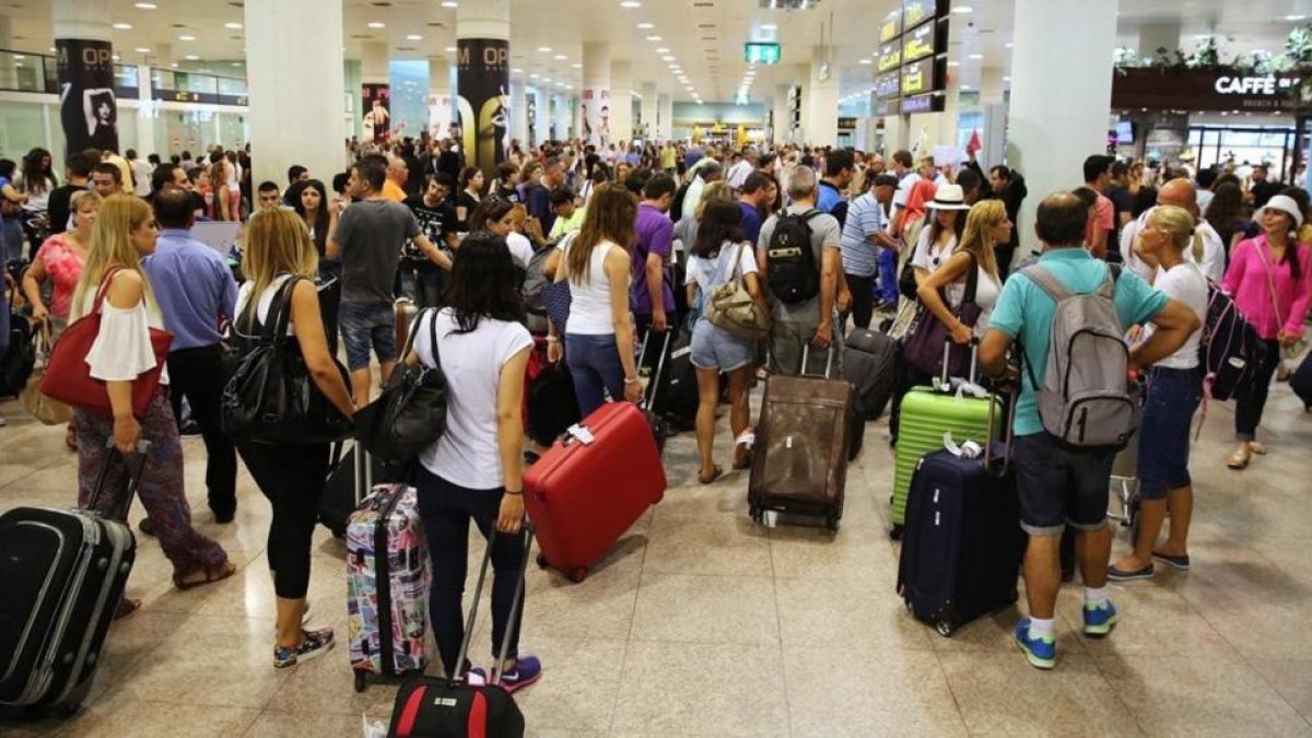 Pasajeros en el aeropuerto de El Prat.-RICARD CUGAT