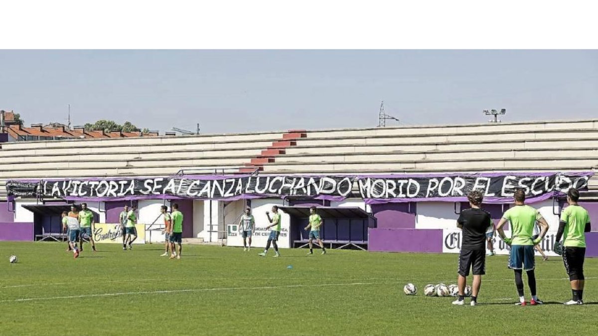 La plantilla albivioleta entrena con una pancarta al fondo que también se vio contra el Llagostera: «La victoria se alcanza luchando, morid por el escudo».-Miguel Ángel Santos