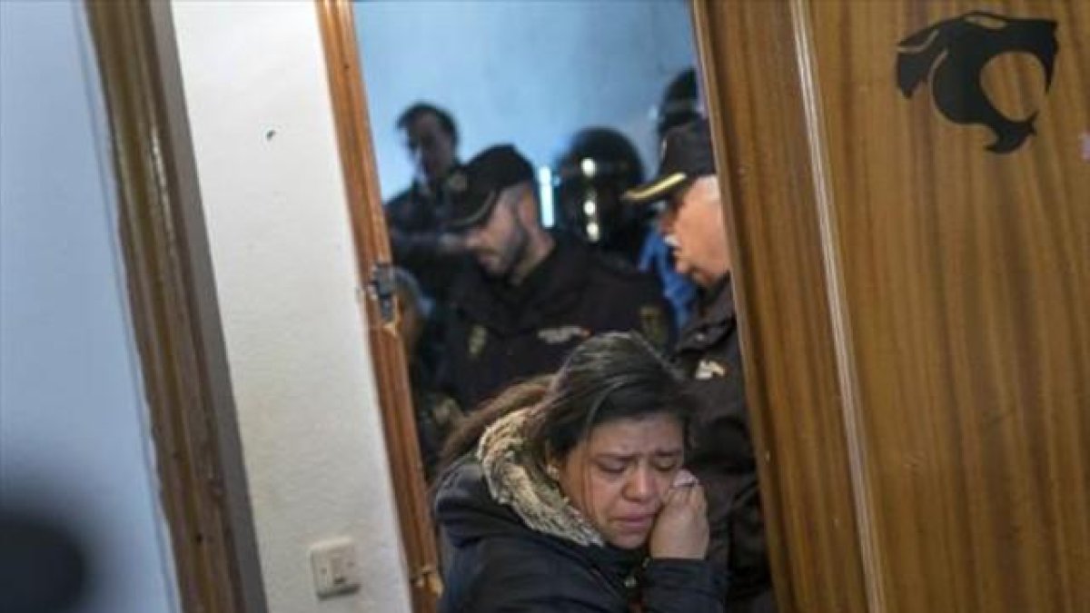 Una mujer abandona llorando la casa ocupada en la que vivía con su familia, tras ser desahuciada por la policía.-AFP / PEDRO ARMESTRE
