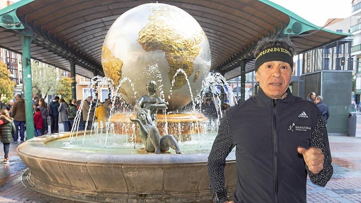 ÁngelFernández corre junto a la bola del mundo de Plaza España.-J.M.LOSTAU
