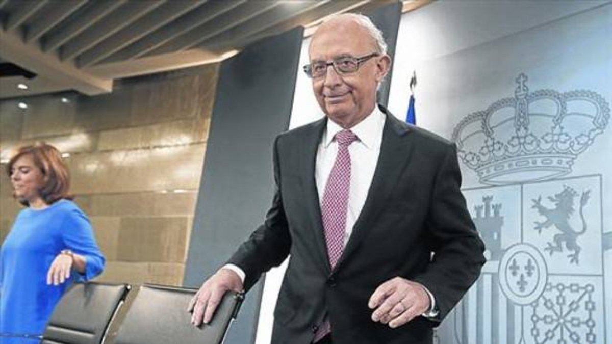 El ministro de Hacienda, Cristóbal Montoro, y la vicepresidenta del Gobierno, Soraya Sáenz de Santamaría, en rueda de prensa en Madrid.-