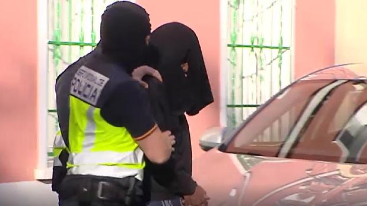 Trasladan al yihadista detenido en Madrid tras el registro en su vivienda. El presunto islamista ha salido de la casa con la cabeza cubierta-ATLAS