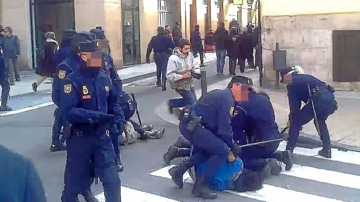 Agentes de antidisturbios reducen a dos manifestantes ante el restaurante de La Parrilla de San Lorenzo.-L. B. ÁLBER