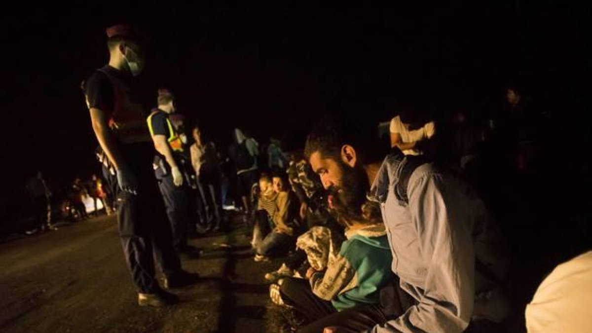 Un grupo de refugiados tras cruzar la frontera entre Hungría y Serbia cerca de Roszke.-EFE / ZOLTAN BALOGH