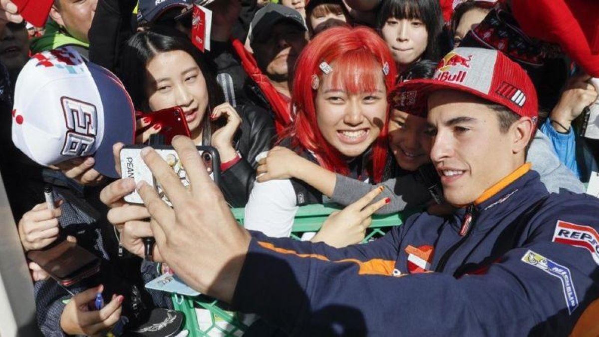 Marc Márquez se hace un selfie con una seguidora en Motegi (Japón).-EFE / KIMIMASA MAYAMA