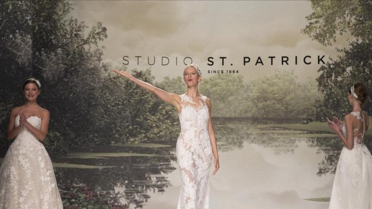 La modelo Karolina Kurkova, junto a dos modelos, saluda al final de desfile de la colección Studio St Patrick 2018.-EFE / MARTA PÉREZ
