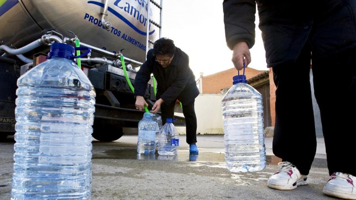 Dos ciudadanos rellenan garrafas con agua procedente de uno de los caminiones cisterna con los que abastecen las diputaciones.-ICAL