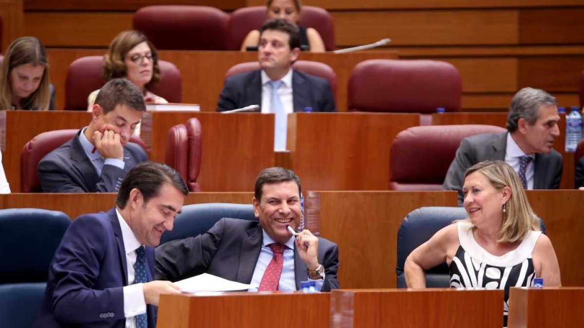 El consejero de Fomento y Medio Ambiente, Juan Carlos Suárez-Quiñones; el consejero de Empleo, Carlos Fernández Carriedo; y la consejera de Economía y Hacienda, Pilar del Olmo; conversan durante el Pleno de las Cortes de Castilla y León.-ICAL