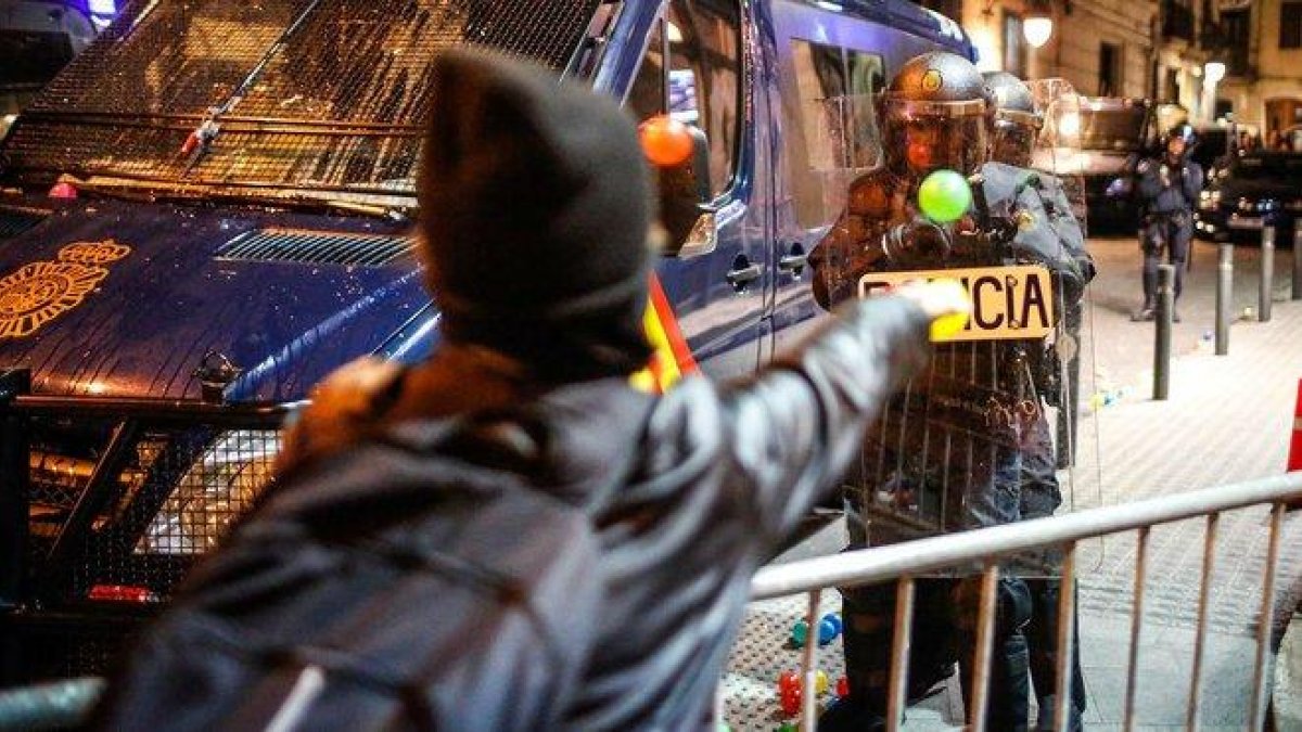 Un manifestante lanza una pelota a un policía, este sábado junto a la jefatura de Via Laietana.-
