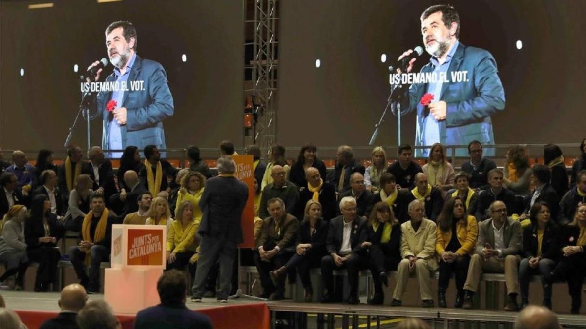 Jordi Sànchez, proyectado en las pantallas del mitin de este viernes en Barcelona, en el que se pasó el audio que grabó desde Soto del Real.-/ PERIODICO (EFE / TONI ALBIR)