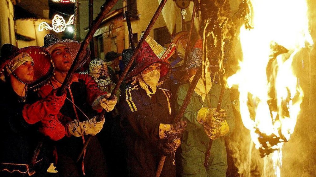 Un grupo de mayorganos portan los pellejos incandescentes en la procesión del Vítor.-J. M. LOSTAU