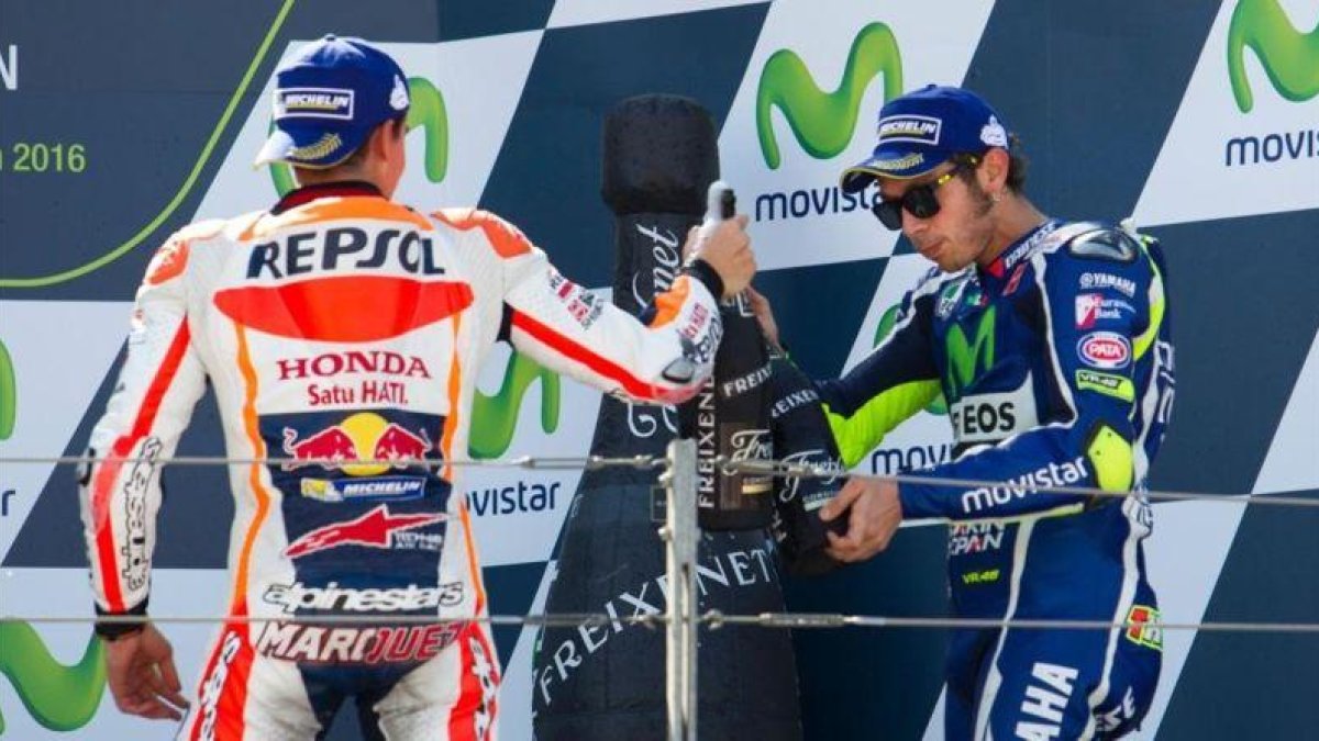 Marc Márquez y Valentino Rossi brindan en el podio de Motorland.-AFP / JAIME REINA