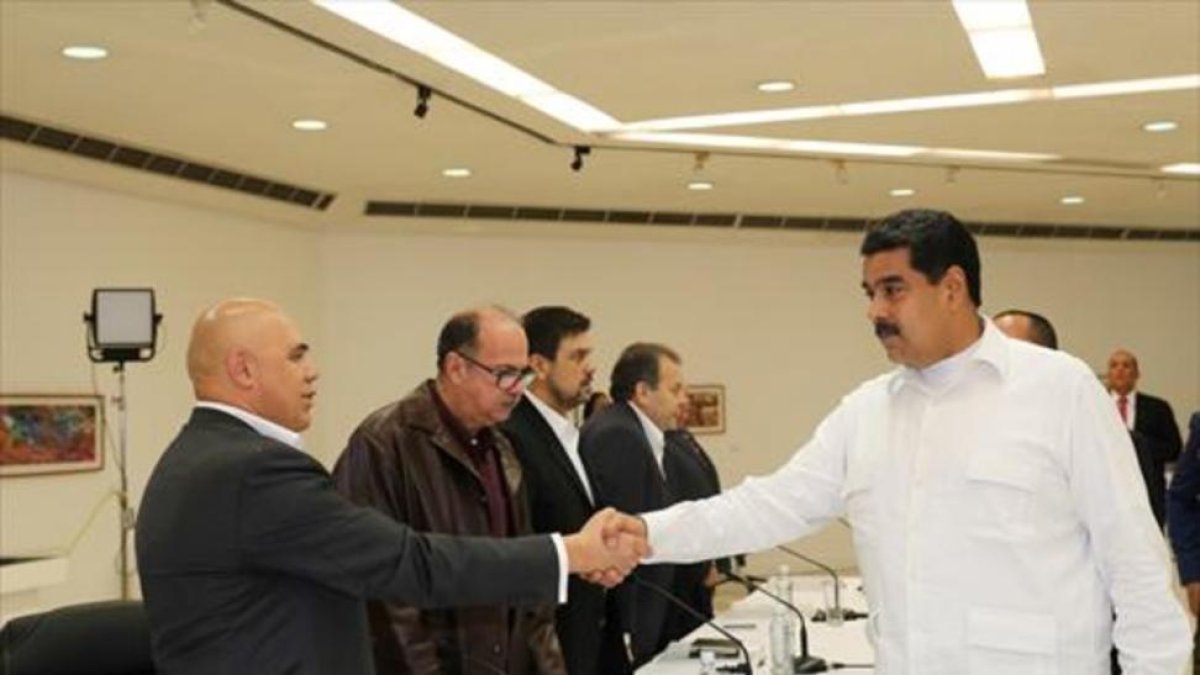 Maduro y el opositor Torrealba se estrechan la mano durante el inicio de la mesa de diálogo en Caracas.-REUTERS