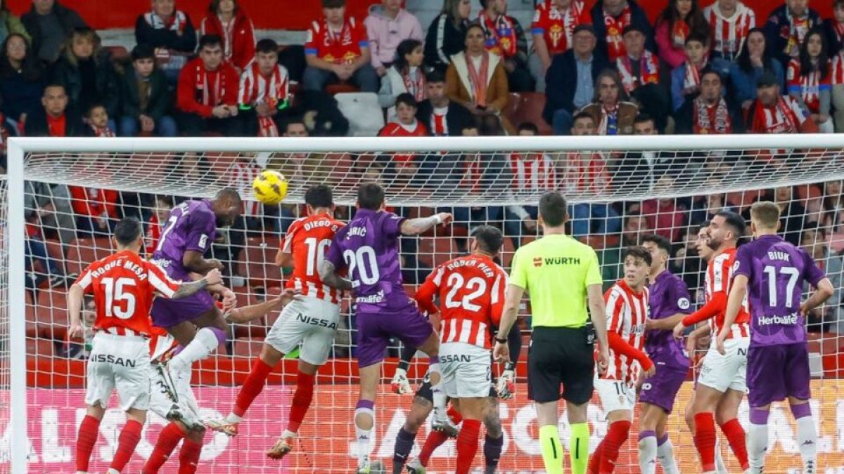 Disputa por el balón en el duelo en El Molinón. / LALIGA