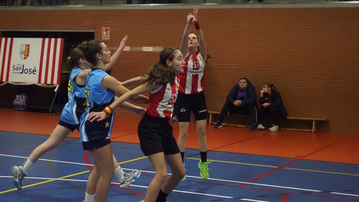 La infantil de san José María Muñoz lanza ante la oposición de dos jugadoras de Lourdes. / M. G. EGEA