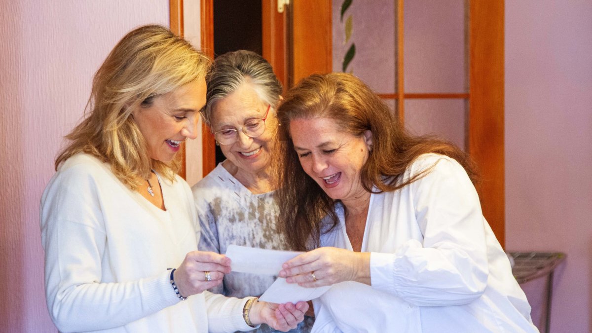 Ángeles Lasarte, 'Angelita' junto a Cristina Arias, voluntaria
del servicio de Acompañamiento contra la Soledad y Marina Fernández, coordinadora del proyecto, observan fotografías antiguas de Angelita en su
domicilio - ICAL