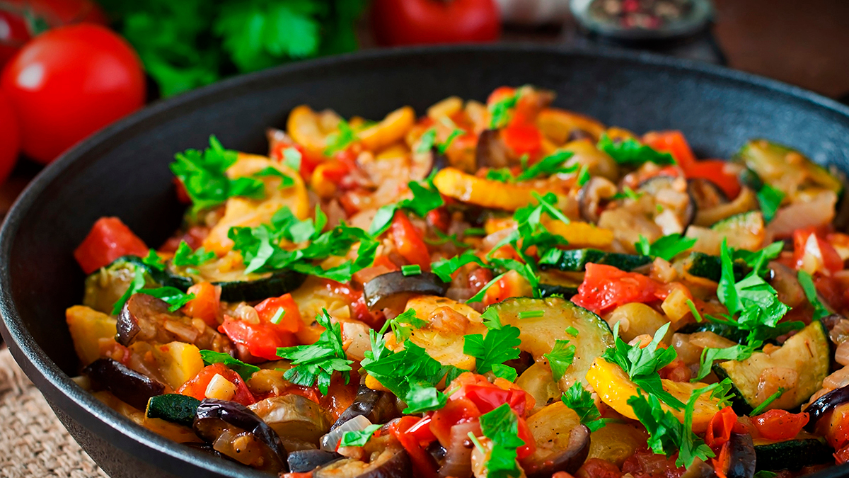 Vegetable Ratatouille in frying pan on a wooden table