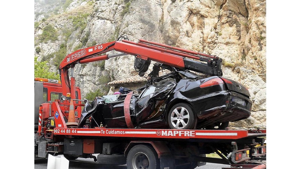 Una grúa transporta el turismo siniestrado.-EL MUNDO