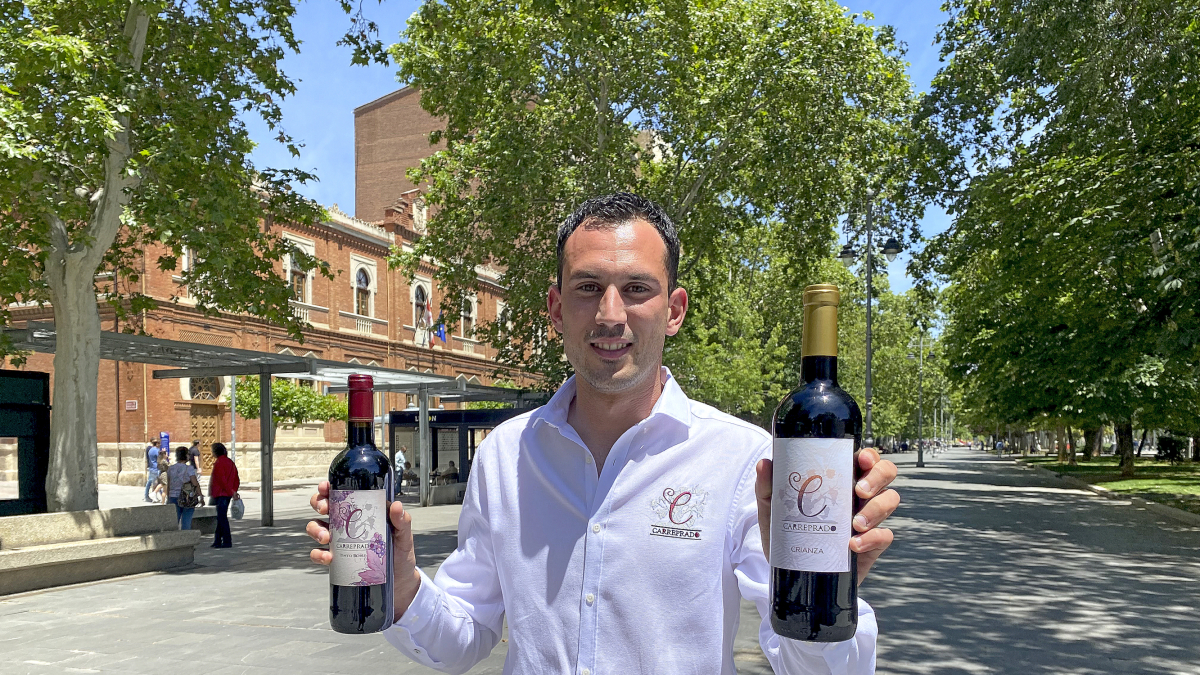 Álvaro Mélida, con dos de sus vinos Carreprado, en el parque del Salón de Palencia.