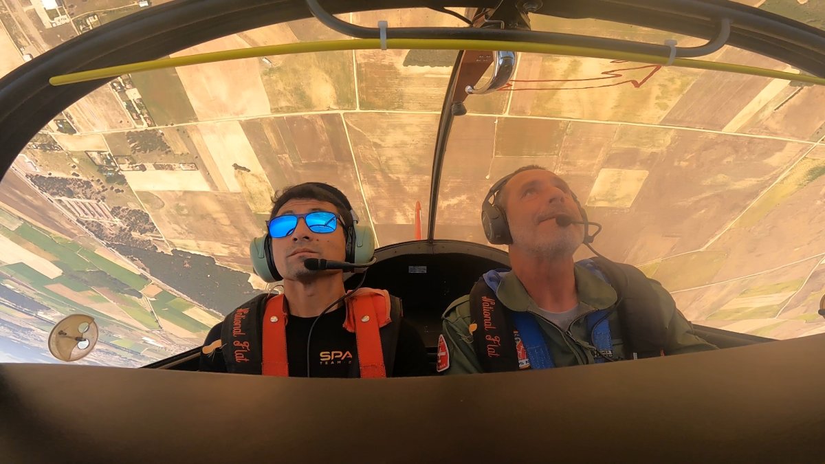 Mario Mondariz (derecha) junto a un instructor de Vuelo durante una acrobacia con el avión invertido.