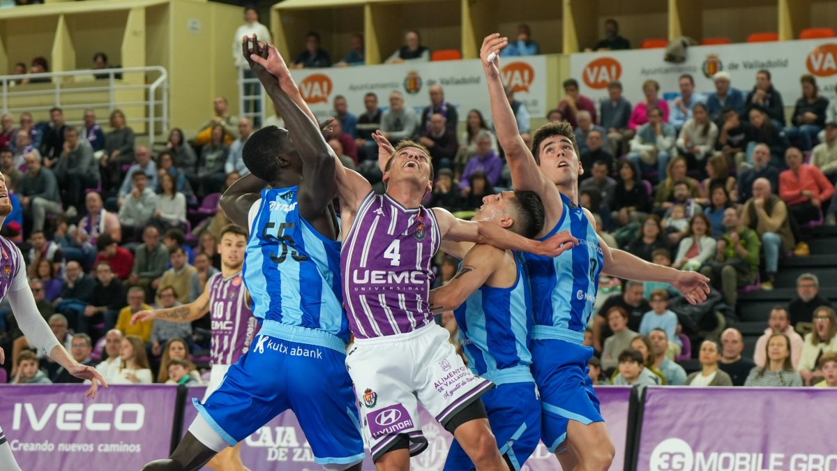 Tres jugadores del Gipuzkoa Basket luchan por un rebote junto al blanquivioleta Atencia.