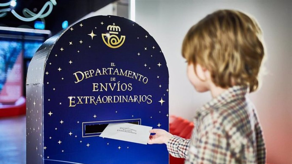 Un niño introduce la carta de los Reyes Magos en un buzón de Correos