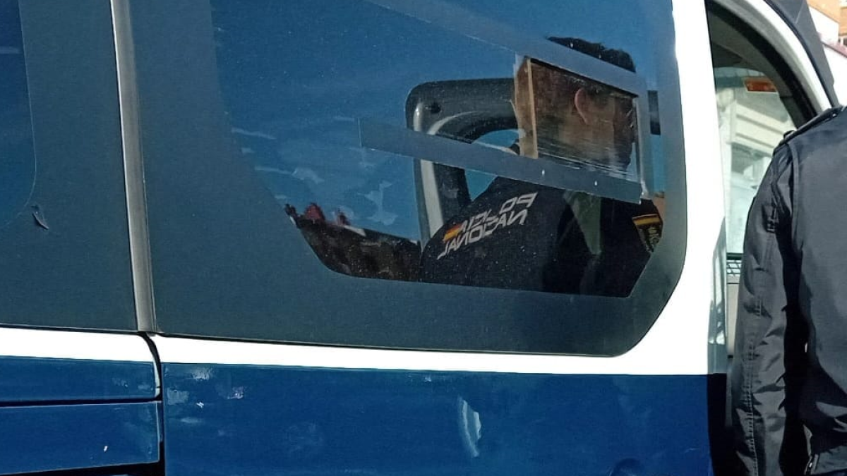 Un agente de la Policía Nacional delante de un furgón.