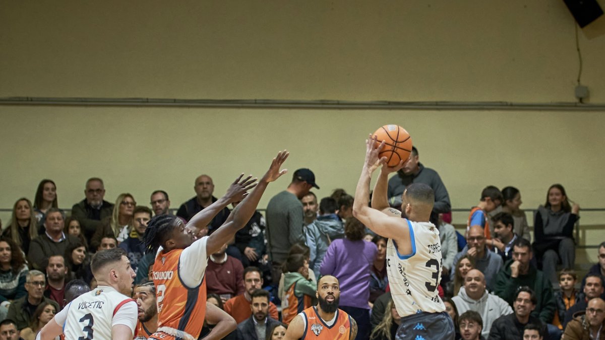 Mike Torres se levanta en suspensión para lanzar ante el punteo de Kouadio.