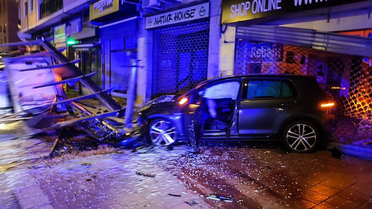 El coche que chocó contra la marquesina y el banco.