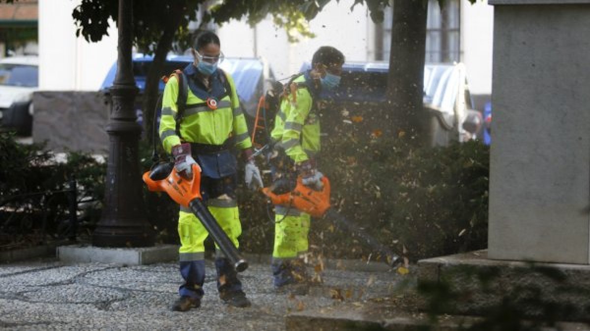 Operarios empleando sopladores de hojas