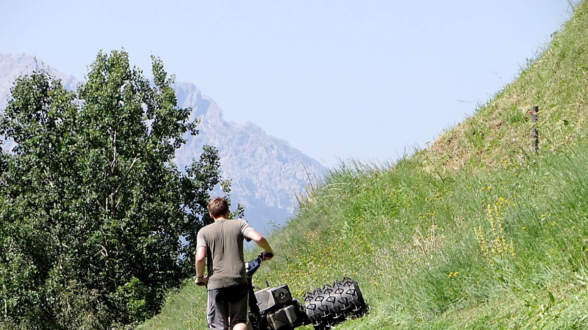 Un joven agricultor utiliza maquinaria de mano en una zona de difícil acceso.