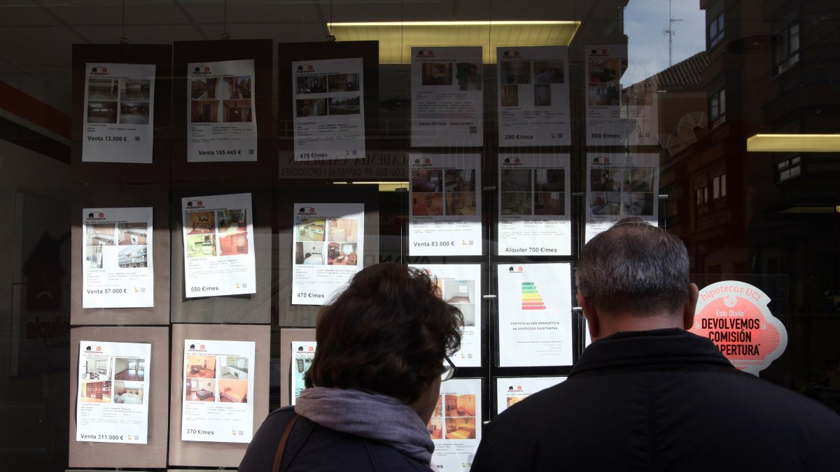 Una pareja mira los anuncios de una inmobiliaria en Valladolid