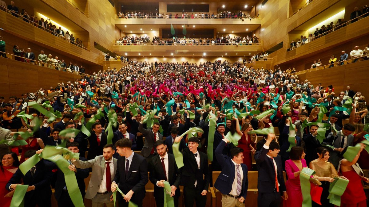 Los graduados de la UEMC agitan las bandas al término del acto en el Auditorio Miguel Delibes.