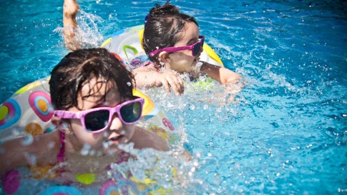 Niños bañándose en una piscina