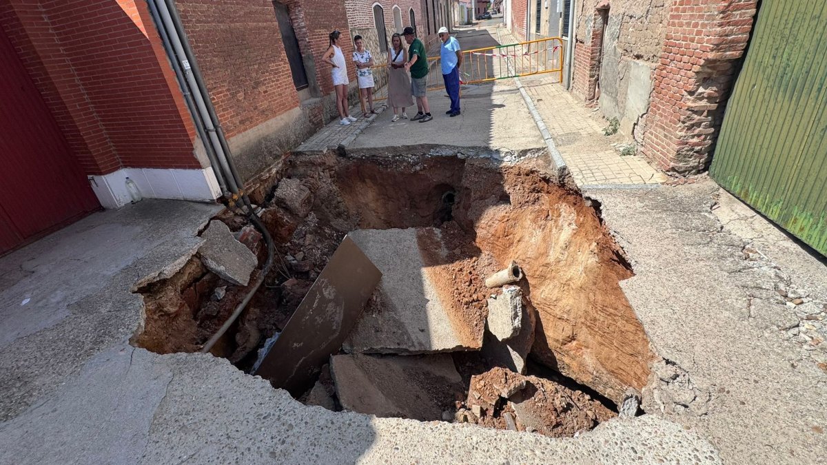 Vecinos de Rodilana observan en enorme socavón en la calle Murga del barrio periférico de Medina del Campo.