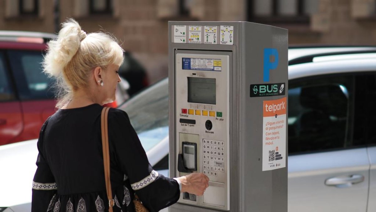 Una mujer saca un ticket para la ORA en uno de los parquímetros de Valladolid.