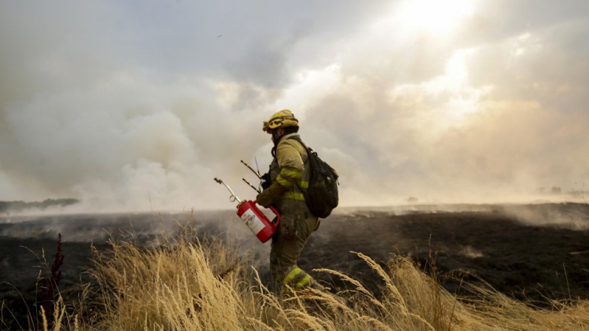 Un bombero trata de extinguir un incendioen Miñambres de la Valduerna (León).