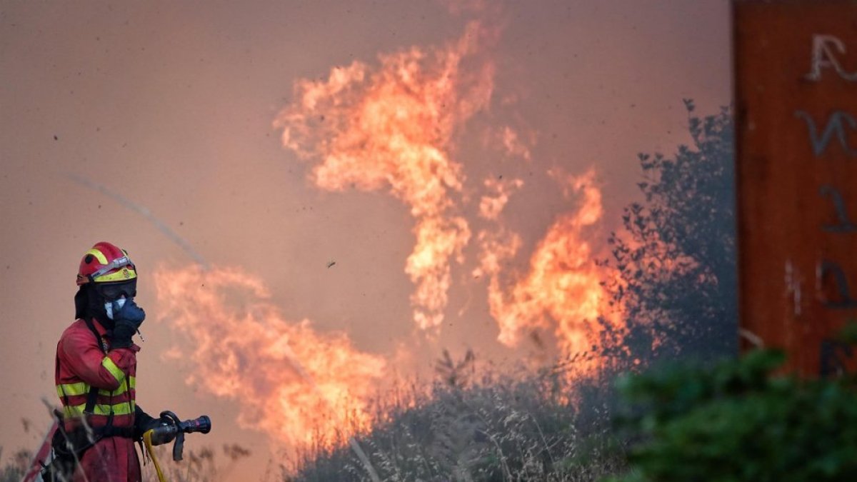 Un bombero trata de apagar el fuego, a 21 de agosto de 2025, en Anllarinos del Sil, León.