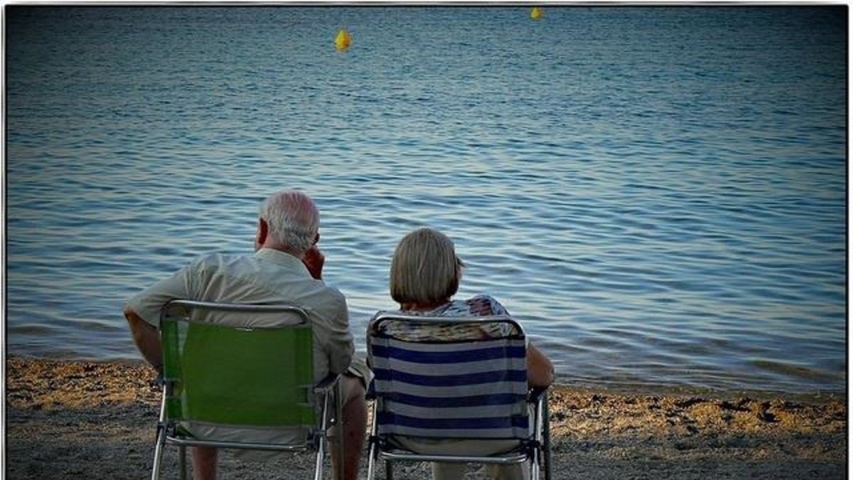 Dos turistas, del programa de turismo del Imserso, descansan en la playa.