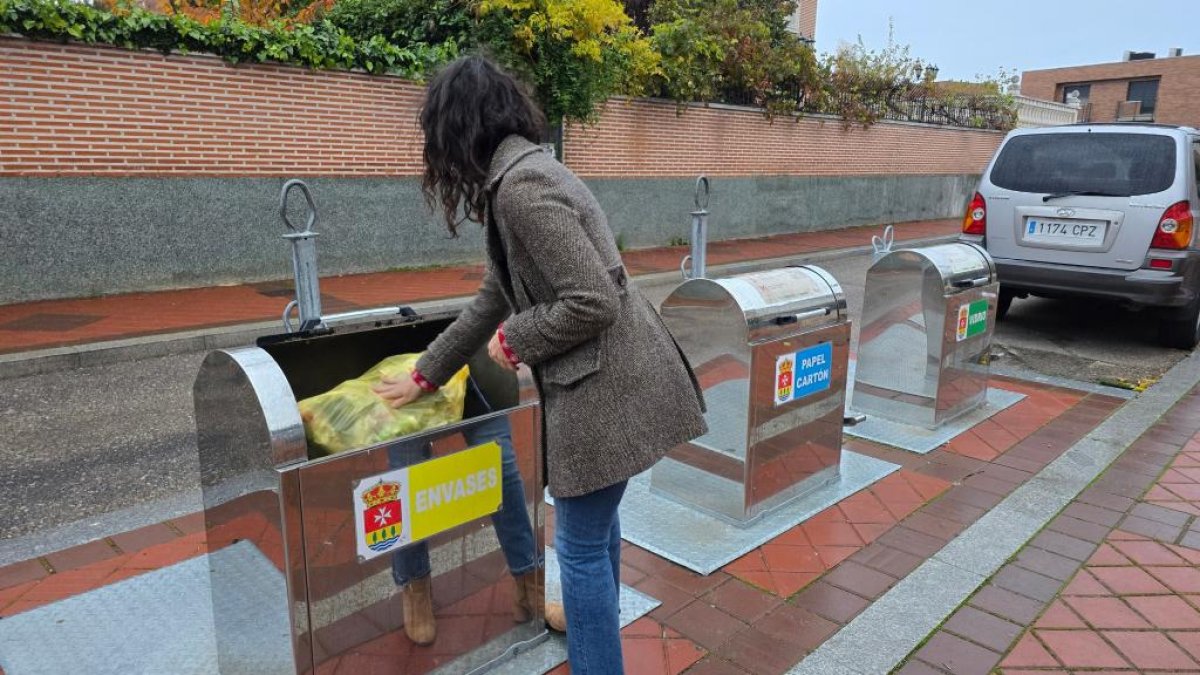 Una persona tira una bolsa de basura en un contenedor de Arroyo.