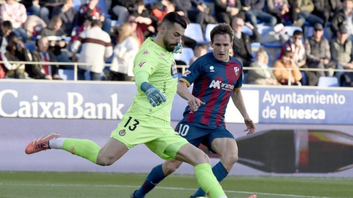 Guilherme se dispone a despejar ante el acoso de Kortajarena, atacante del Huesca.