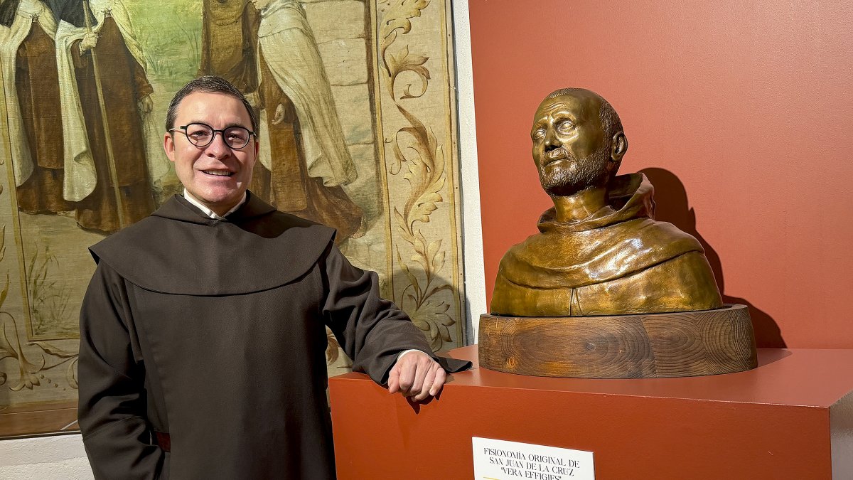 Miguel Ángel González posa junto a un busto de san Juan de la Cruz.