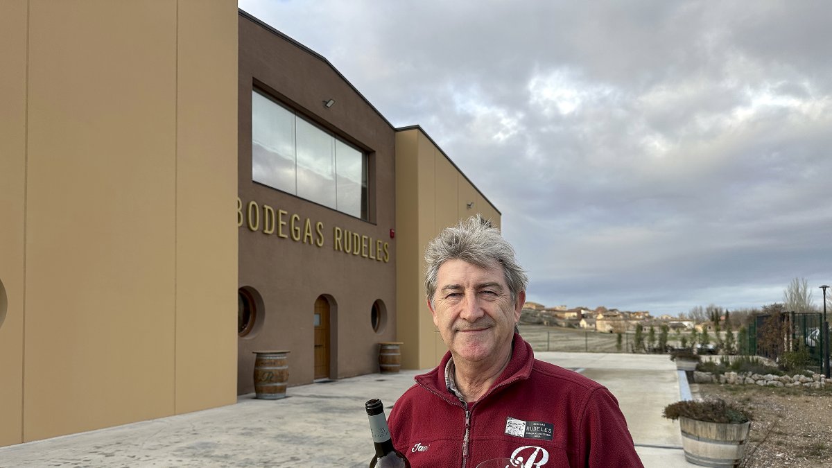 Javier Rupérez dando la espalda a las instalaciones de la moderna bodega de Rudeles con su pueblo Peñalba de San Esteban al fondo.