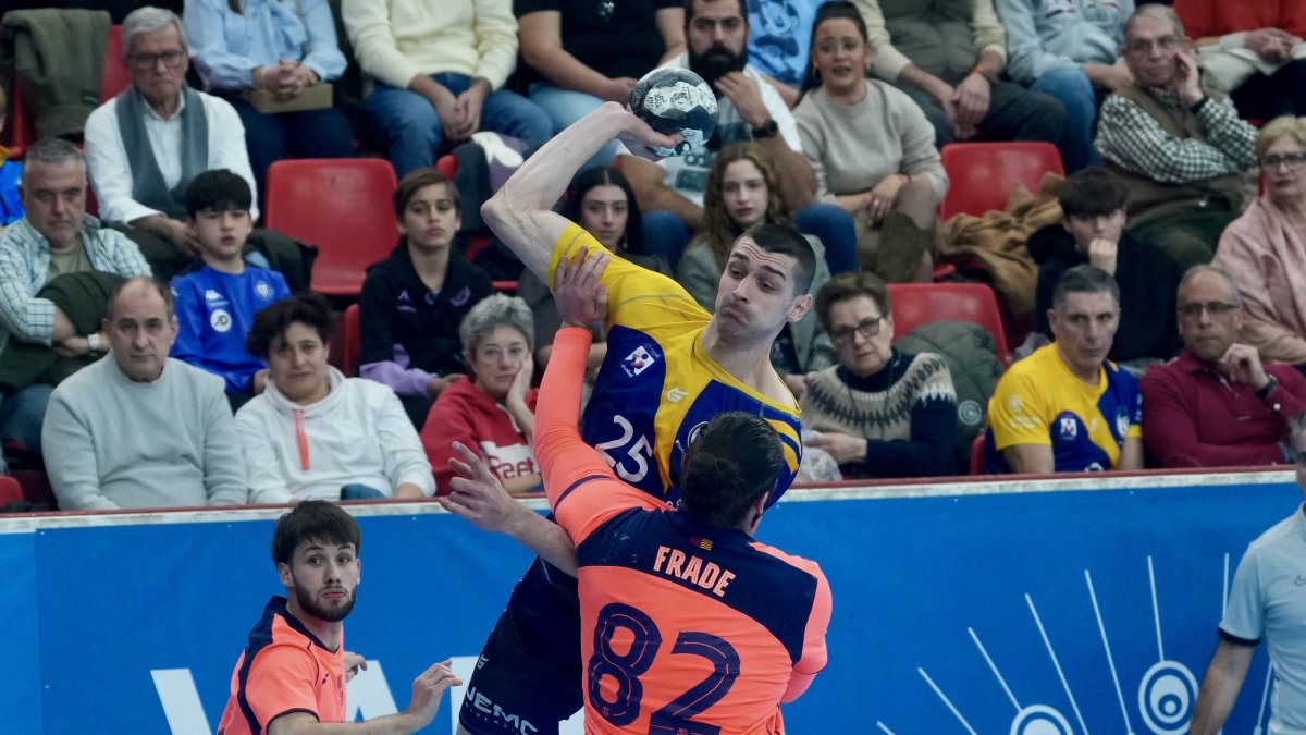 El lateral Fodorean busca el tiro, defendido sobre el brazo ejecutor por el pivote Frade.